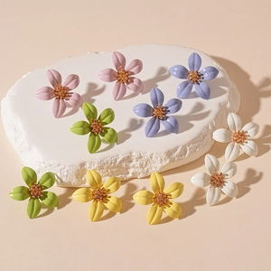 Colorful floral petal stud earrings in candy colors on minimalist display base