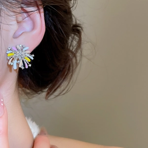 Detailed close-up of fireworks-shaped silver earrings with colorful enamel petals and crystals