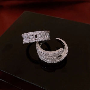 Detailed close-up of silver-plated rings featuring zircon stones and a central CD logo