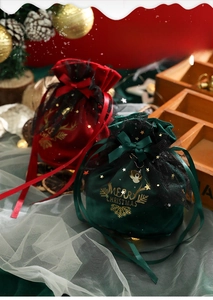Detail of red and green velvet Christmas gift bags with gold reindeer and star mesh