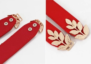 Detail of red leather belt with gold leaf-shaped buckle and back screw structure