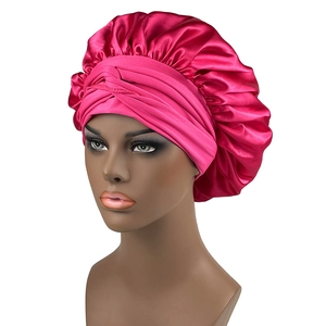 Dettaglio della cuffia da notte in raso rosa acceso con texture liscia e fascia elastica larga