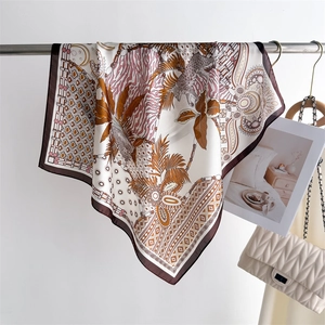 Detail of silk square scarf featuring leopard and palm prints on a metal display rack