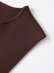 Detailed close-up of dark brown knit fabric shoulder and neckline texture on white back