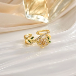 Detailed close-up of a gold flower open ring with green leaves and zircon inlay