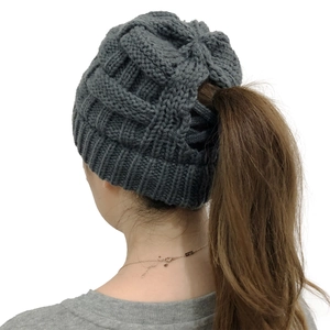 Close-up of dark grey cable knit ponytail beanie with functional back opening detail