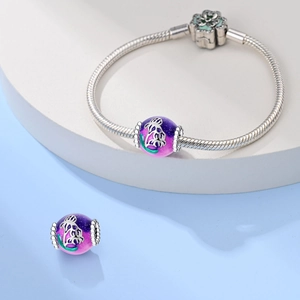 Detail of silver snake chain bracelet with purple gradient enamel flower charm bead