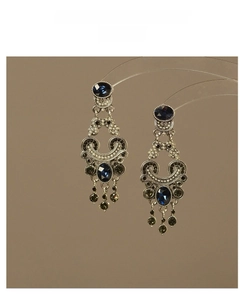 Detail of vintage palace style earrings with blue gems, pearls and tassels