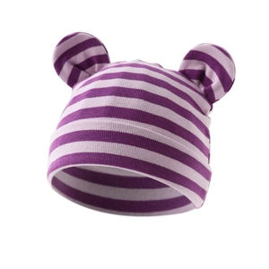 Close-up of purple and pink striped baby beanie with cute round ears and ribbed knit texture