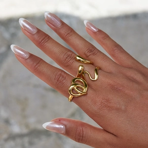 Detailed view of an 18K gold-plated stainless steel knot ring on a model's index finger