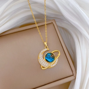 Detail von Goldmond-Anhänger mit blauer Galaxie und Kristallen auf weißer Seide