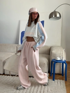 Detail of grey and pink cropped sweatshirt with letters and matching wide-leg sweatpants