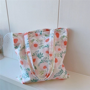 Vue détaillée d'un grand sac cabas en toile avec motifs floraux et étiquette cousue