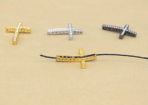 Detailed view of rhinestone cross pendants showing the threading hole for DIY jewelry