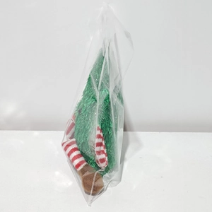Detail of plush Christmas tree doll with red striped long legs in clear packaging
