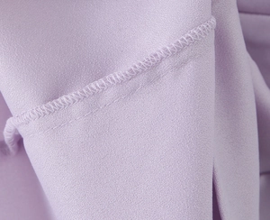 Vue macro détaillée de la texture du tissu tissé violet et des coutures d'une mini robe