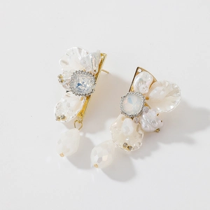 Detailed macro view of white flower crystal earrings with drop pearl and gold plating