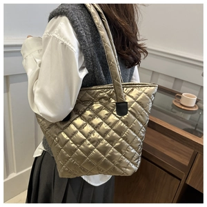 Vue mannequin d'un grand sac cabas matelassé couleur champagne doré avec fini métallisé