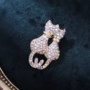 Detailed view of dual cat brooch featuring vibrant rainbow rhinestones and gold setting
