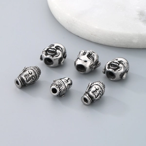 Macro view of six stainless steel Buddha head spacer beads for DIY jewelry making