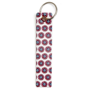 Macro detail of faux leather keychain featuring evil eye pattern and precise stitching