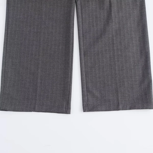 Detailed macro view of gray herringbone fabric texture and wide leg pant hem finish