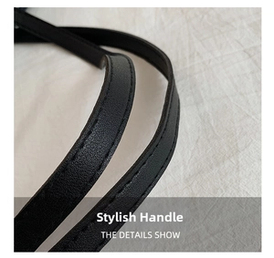 Detail shot of the black tote bag handle featuring premium leather texture and stitching
