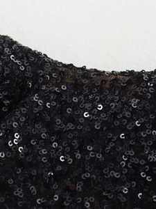 Macro shot of shimmering black sequins on sheer mesh fabric for a slim-fit evening dress