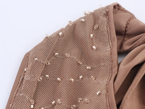 Detail of beaded mocha mesh top with hand-stitched sequins for festival wear
