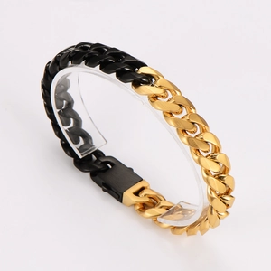 Macro detail of two-tone gold and black Cuban link bracelet with secure clasp closure