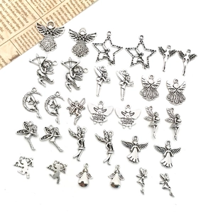 Detailed flat lay of antique silver angel and cupid charms for DIY jewelry making