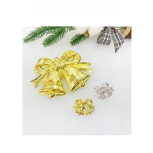 Close-up of gold and silver Christmas bells with red bows on snowy background