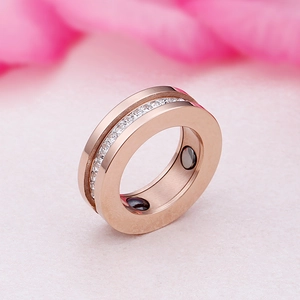 Rose gold titanium steel magnetic ring with white diamonds on a soft floral background
