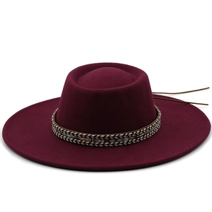Close-up of wine red wool pork pie hat with ethnic woven band and brown leather tie