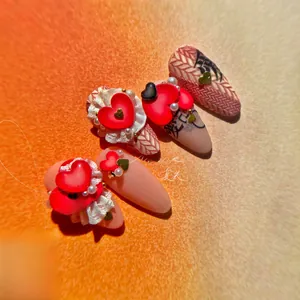 Detail of pink and red 3D nail stickers with hearts, pearls and Chinese characters