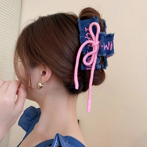 Detail of denim bow hair claw clip with pink accent rope and 'I can' embroidery
