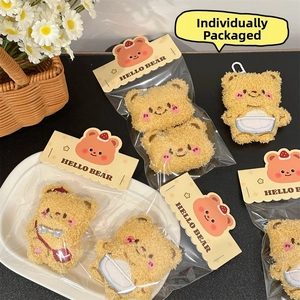 Macro detail of plush bear pendants in warm brown colors with cute embroidered faces