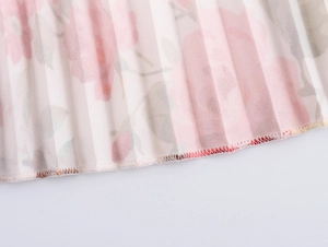 Detailed view of the pleated floral dress hem showing pink flowers and serged stitch edges