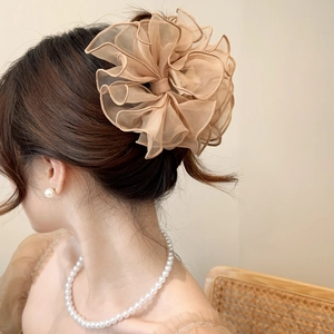 Détail d'une pince à cheveux avec nœud en organza champagne portée par un mannequin