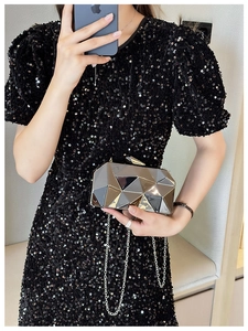 Detail of silver geometric acrylic clutch bag with shiny mirror-finish triangular panels