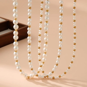 Elegant gold beads and mixed size pearl necklace draped over a jewelry box display