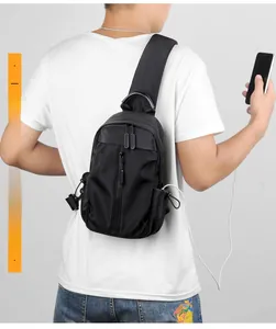 Detail of crossbody chest bag featuring external USB charging port in use by model