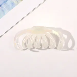 Detail shot of a pearlescent white hair claw clip with aurora finish on white background