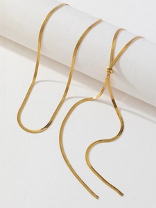 Detail of adjustable gold snake chain necklace showing flat texture and sliding ball clasp