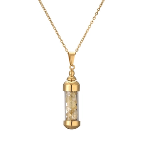 Close-up of golden cylinder perfume bottle pendant necklace with yellow crystal stones