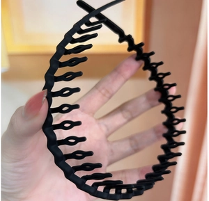 Detail view of black matte wavy toothed headband for secure hair styling and face washing