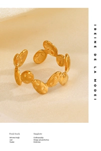 Detail of gold oval textured ring with organic bubble pattern on beige fabric