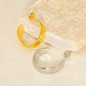 Detailed macro view of two-tone C-shaped chunky earrings with high-polish mirror finish