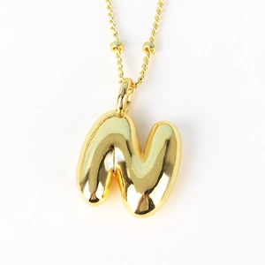Detail of puffed 3D letter N pendant in gold with textured beaded rope chain