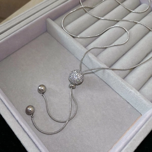 Detail of silver snake chain necklace with a round rhinestone pendant in a jewelry box